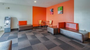 A lobby with a check-in counter, seating area, and a wall-mounted ATM. - Motel 6 Drums, PA (Drums)