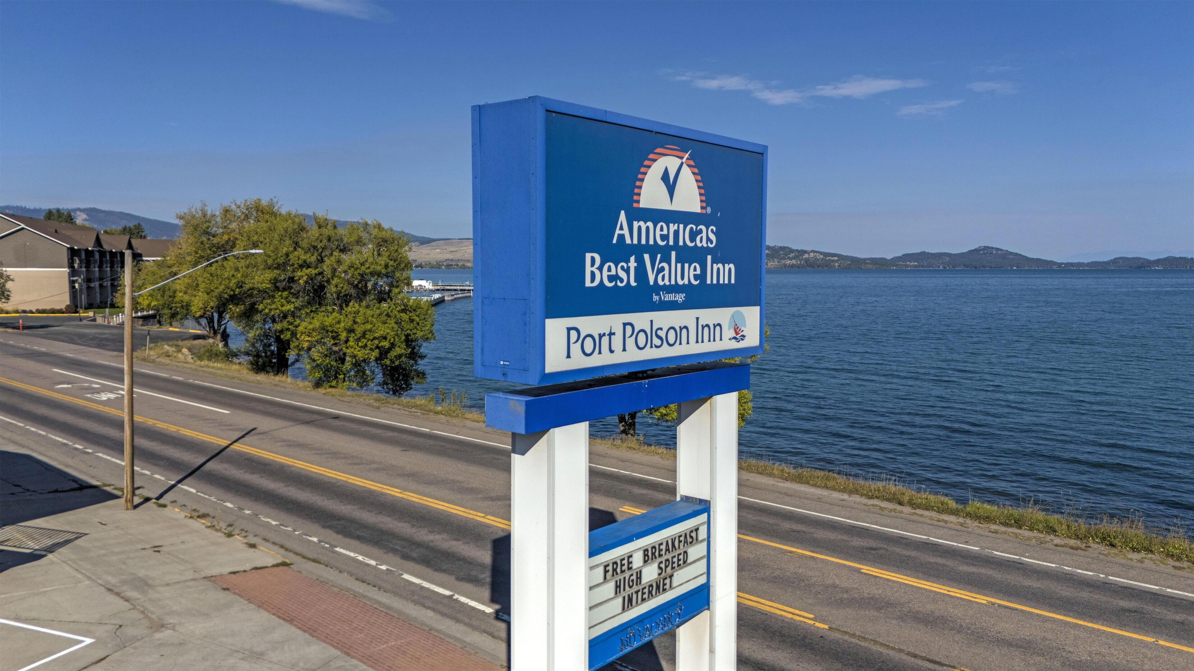 A blue sign for Port Polson Inn, featuring amenities like free breakfast, high-speed internet, and a view of the water.