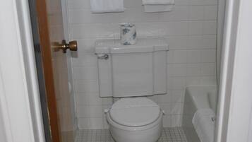 A bathroom with a toilet, a bathtub, and a toilet paper roll on the tank.