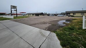 Un estacionamiento amplio con una gasolinera y un motel.