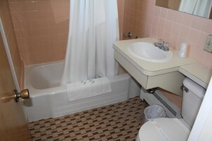 Un baño con bañera, lavamanos e inodoro.