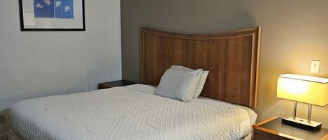 Desk, laptop workspace, iron/ironing board, bed sheets