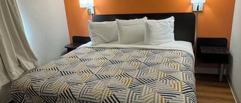 A hotel room with a bed, two bedside tables, and a nightstand.