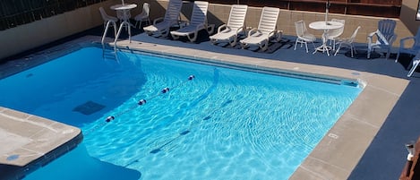 Una piscina al aire libre de temporada, sombrillas