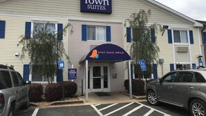 A hotel with a sign reading "In Town Suites" and a slogan "Stay Save Smile".