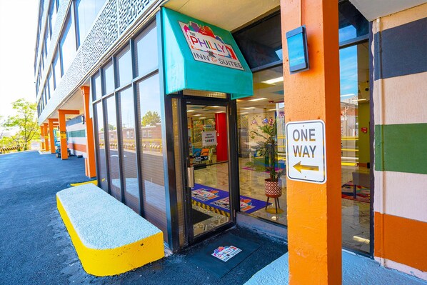 A hotel entrance with a 'One Way' sign, a visible lobby area, and a '5' parking sign.