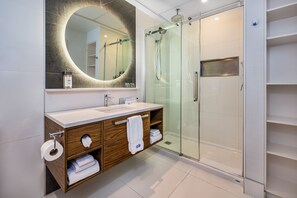 Een bad/douchecombinatie, een regendouche, designer toiletartikelen