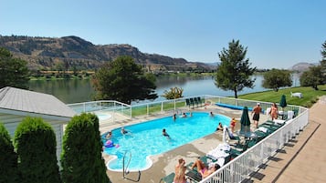 Una piscina al aire libre de temporada, sillones reclinables de piscina