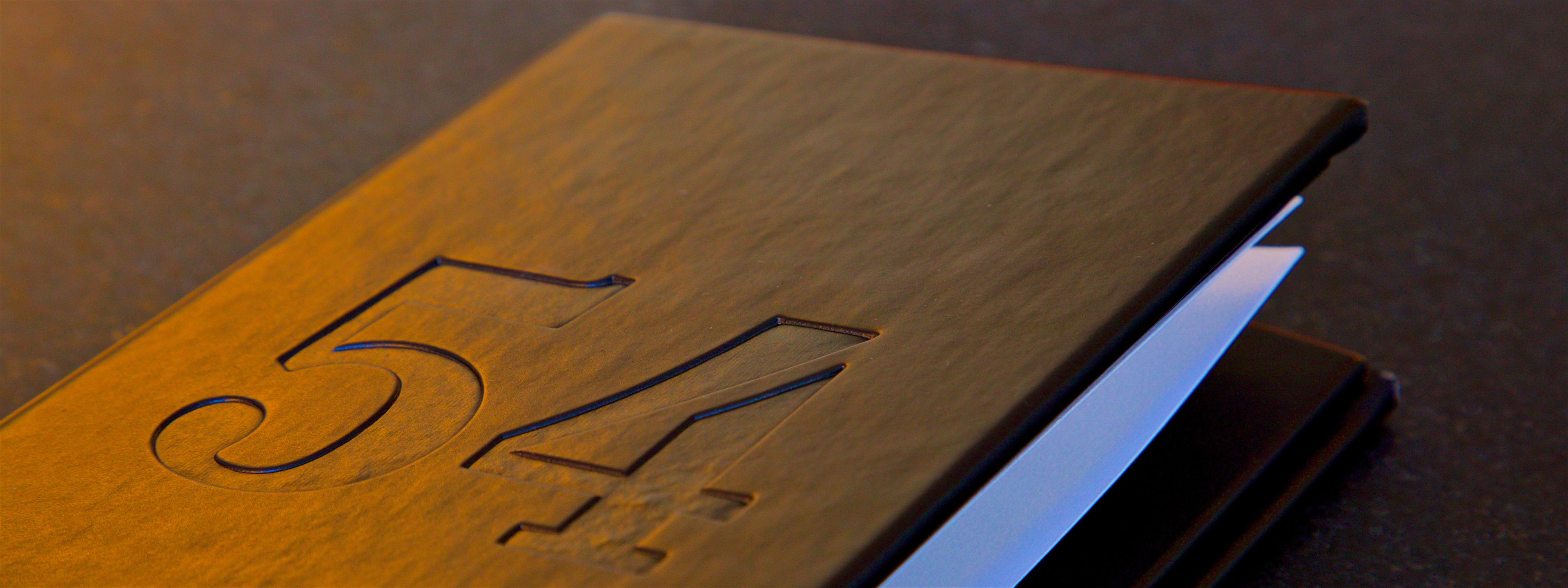 Un objet en bois portant le numéro « 54 » gravé dessus.