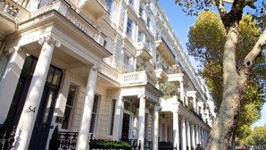 Une rangée de bâtiments classiques aux façades blanches, dotés de grandes colonnes et de balcons.