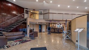 A spacious lobby with a staircase, a reception desk, and a seating area. - Best Western Marquis Inn & Suites (Prince Albert)
