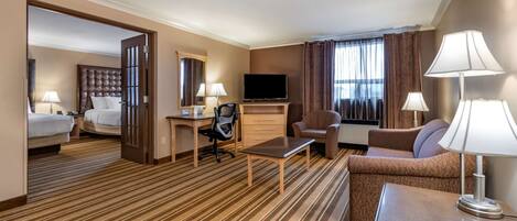 A hotel room with a bed, a desk, a television, a sofa, and a chair.