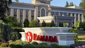 Un edificio moderno con un letrero que dice "RAMADA" y el número "4520" sobre una base blanca.