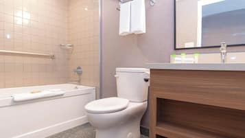 A modern bathroom with a bathtub, toilet, and vanity.