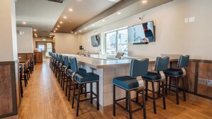 A modern bar area with a long counter and multiple stools.