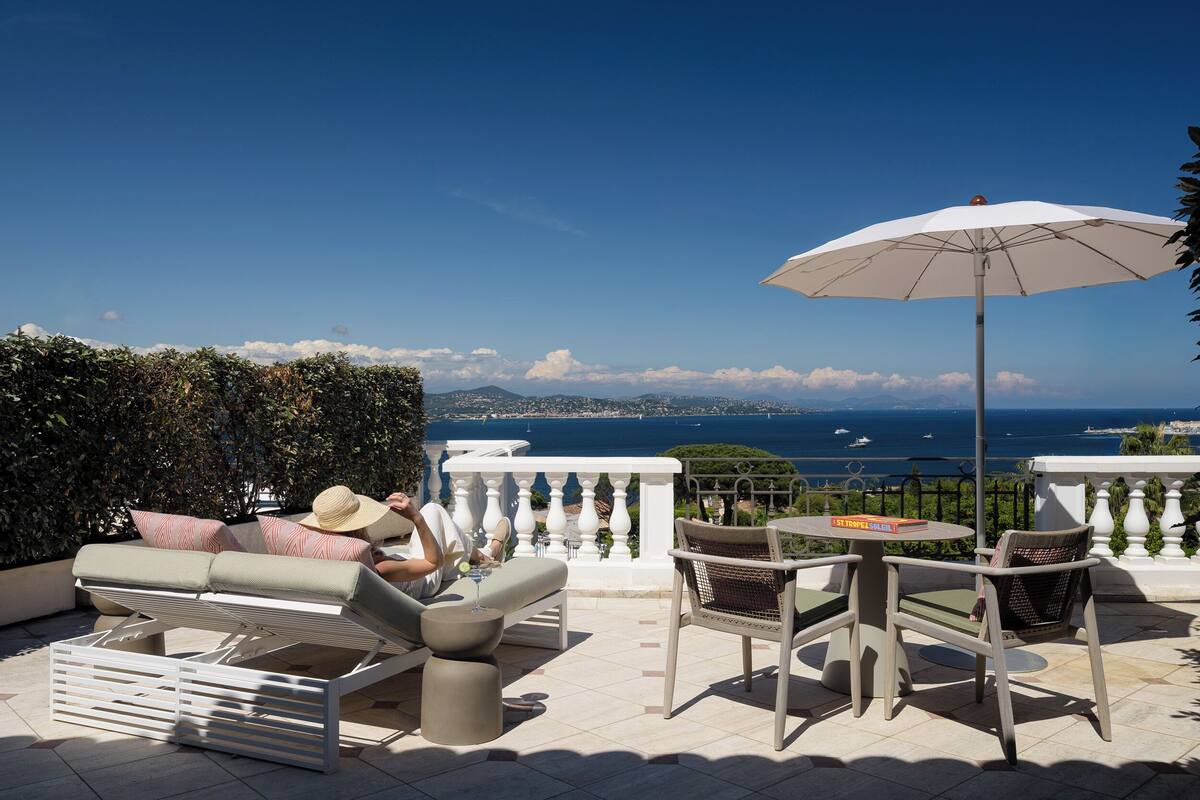 A terrace with outdoor seating, a table, and an umbrella.