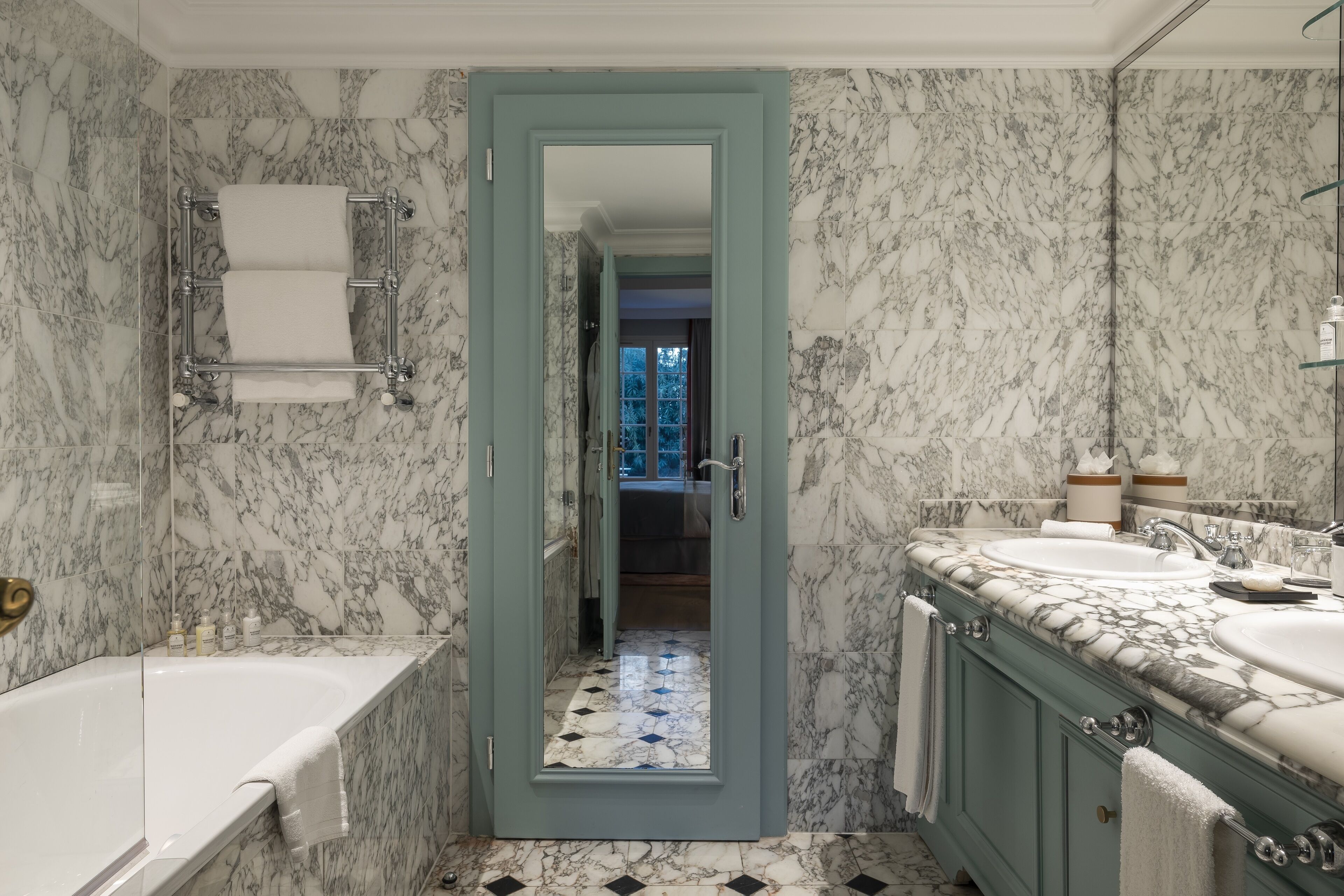 Un baño con paredes de mármol y una bañera.