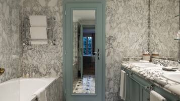 A bathroom with marble walls and a bathtub.