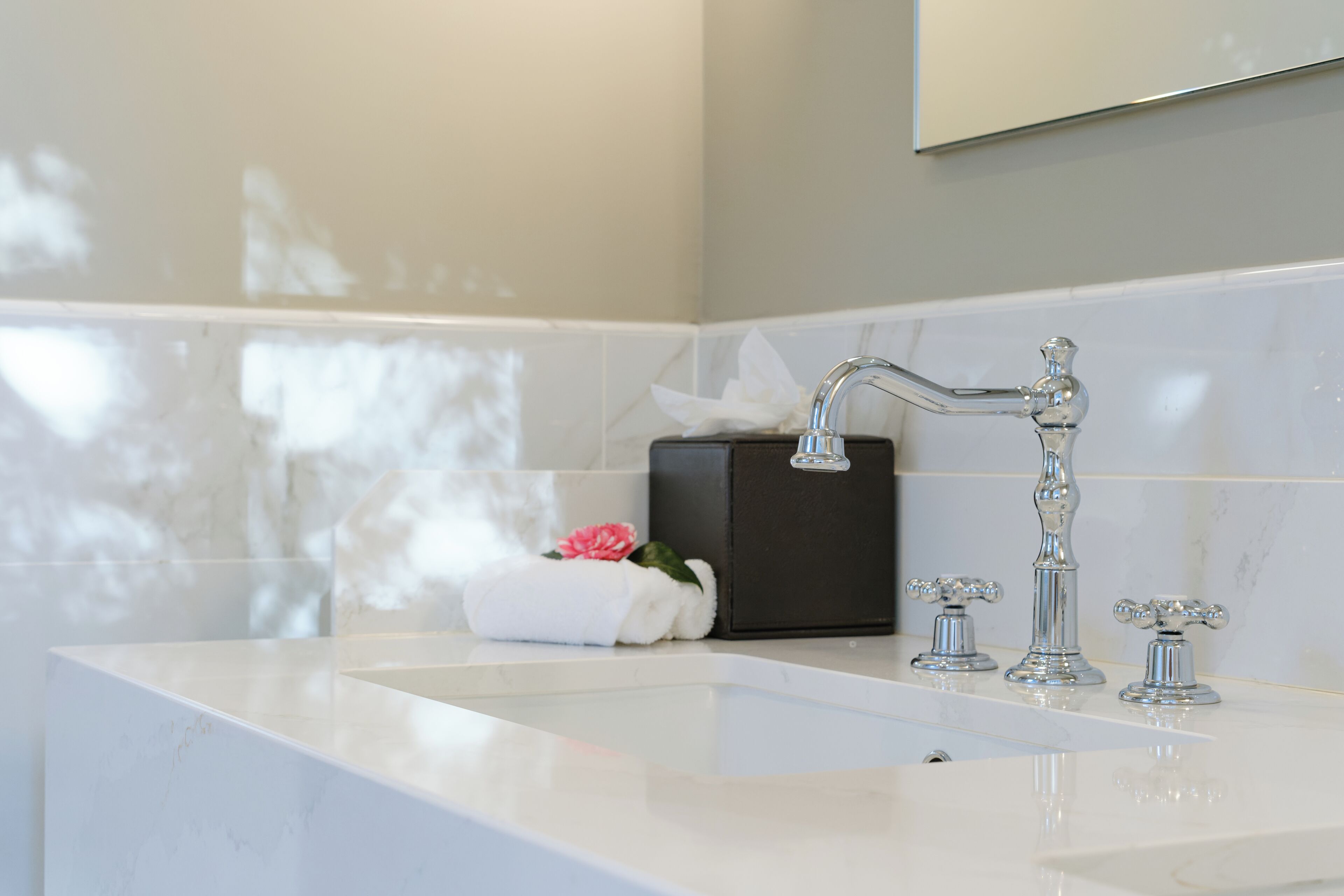 A bathroom with a white sink, a towel, and a tissue box.