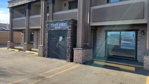 A building with a sign reading "Tipsy Pint Bar & Grill" at the entrance. - Super 8 by Wyndham Red Deer (Red Deer)