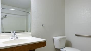 Un baño con lavamanos blanco, un espejo, inodoro y ducha.