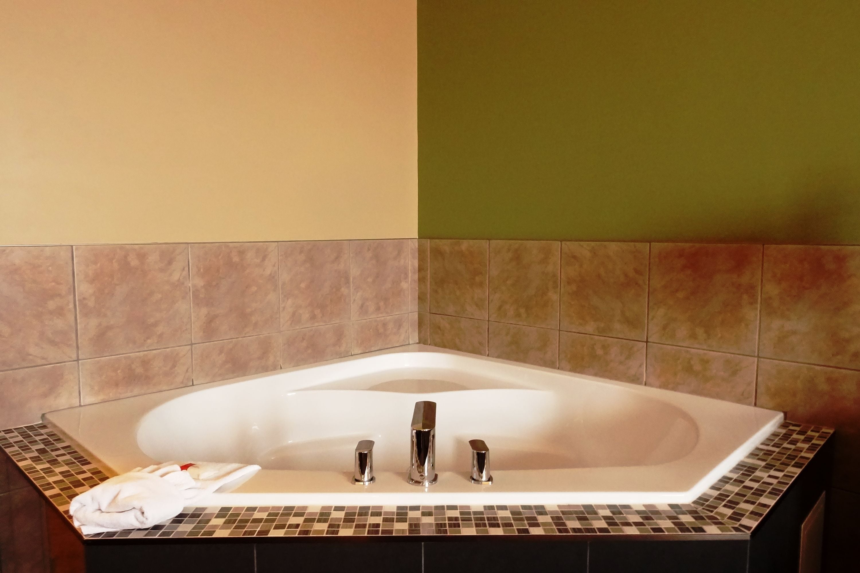 A modern bathroom with a freestanding bathtub, a towel, and a shower area.