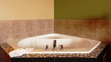 A modern bathroom with a freestanding bathtub, a towel, and a shower area.