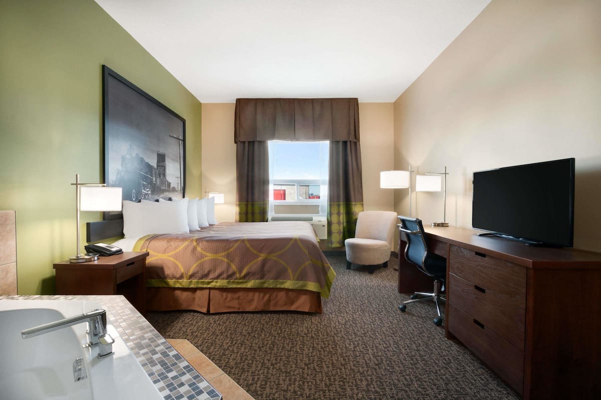 Une chambre d’hôtel avec un lit, un bureau, une télévision et une salle de bain.