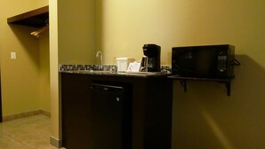 Une petite cuisine équipée d’une machine à café, d’un four à micro-ondes et d’un lave-vaisselle.