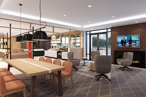 Un intérieur moderne comprenant un coin repas, des sièges, une cheminée et un écran de télévision.