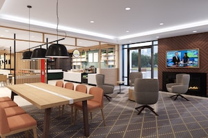 Un interior moderno con comedor, asientos, chimenea y pantalla de televisión.