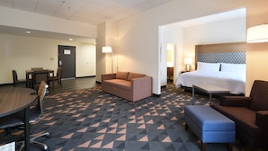 Une chambre d’hôtel avec un lit, un canapé, un bureau et une chaise.