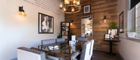 A dining area with a wooden wall, a chandelier, and a table with chairs.