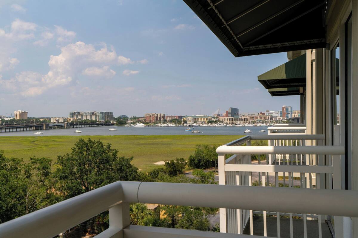 A balcony with a view of a marina and city skyline.