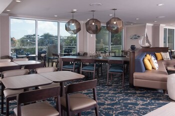A hotel room with a sofa, a bed, a desk, and a TV. at SpringHill Suites Charleston Riverview 