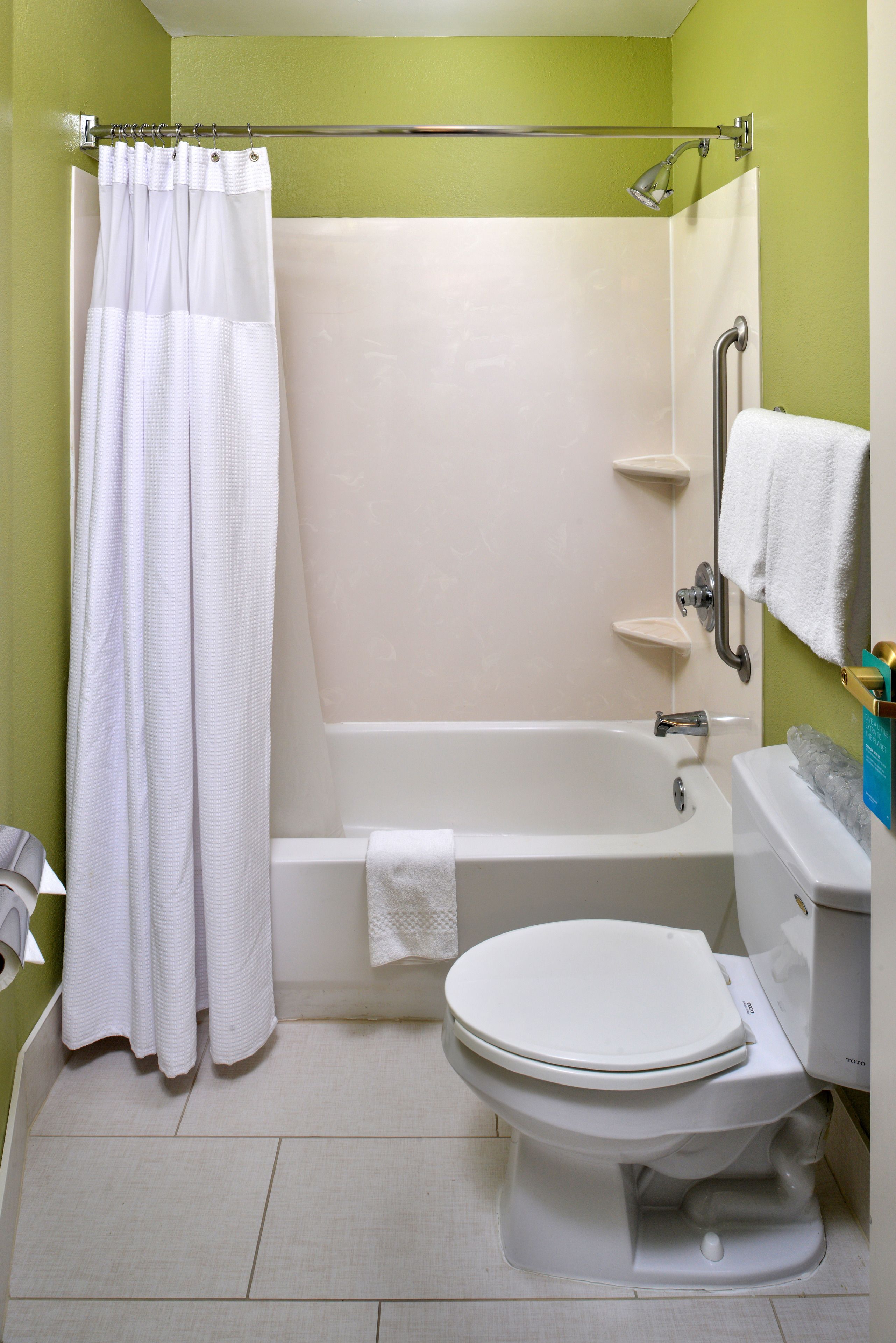A bathroom with a bathtub, toilet, and shower.