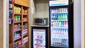 Un quiosco autoservicio con aperitivos, bebidas y un microondas.