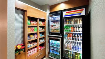 Una pequeña kitchenette equipada con refrigerador, congelador y despensa llena de alimentos.