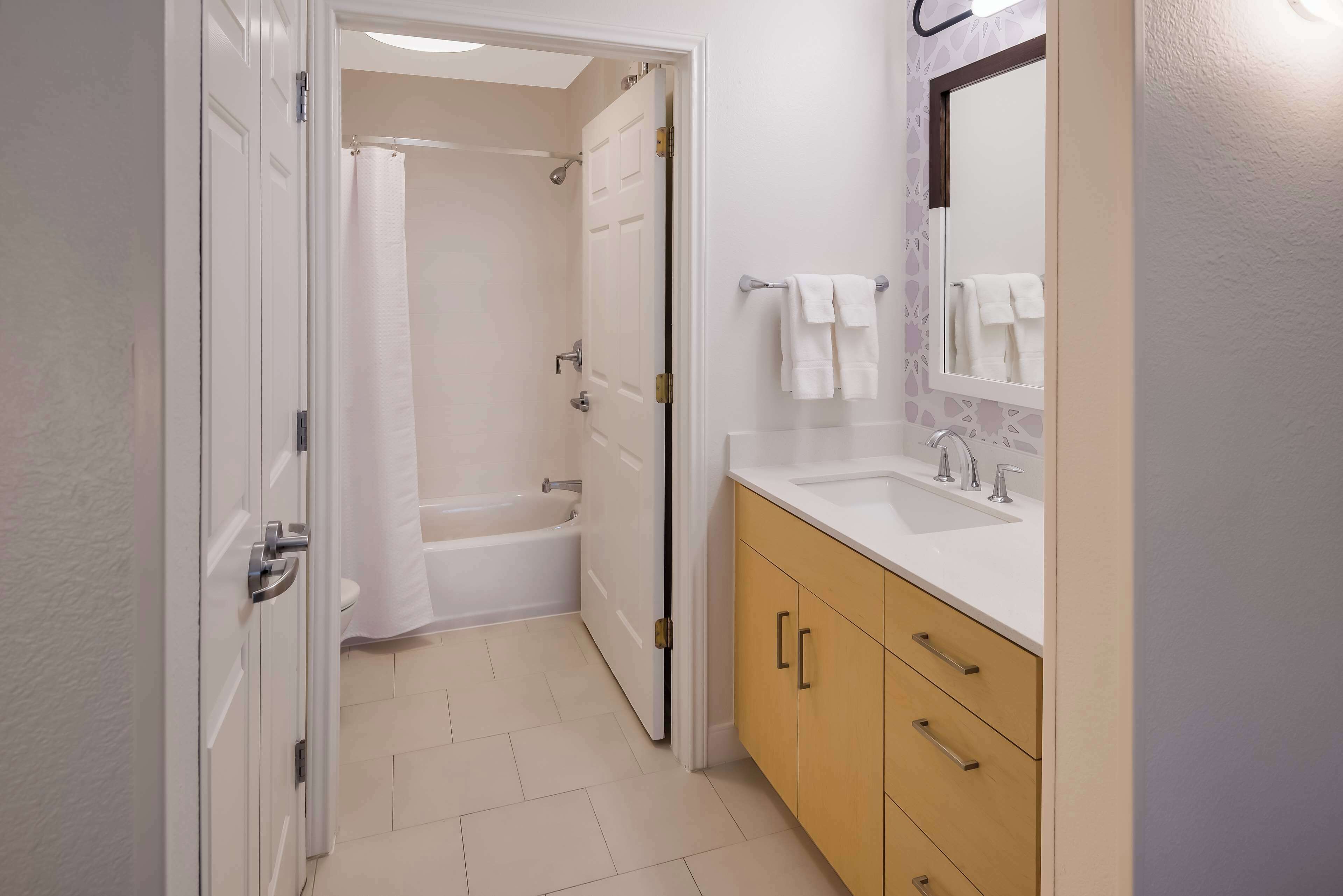Un baño con bañera, ducha y lavabo con espejo.