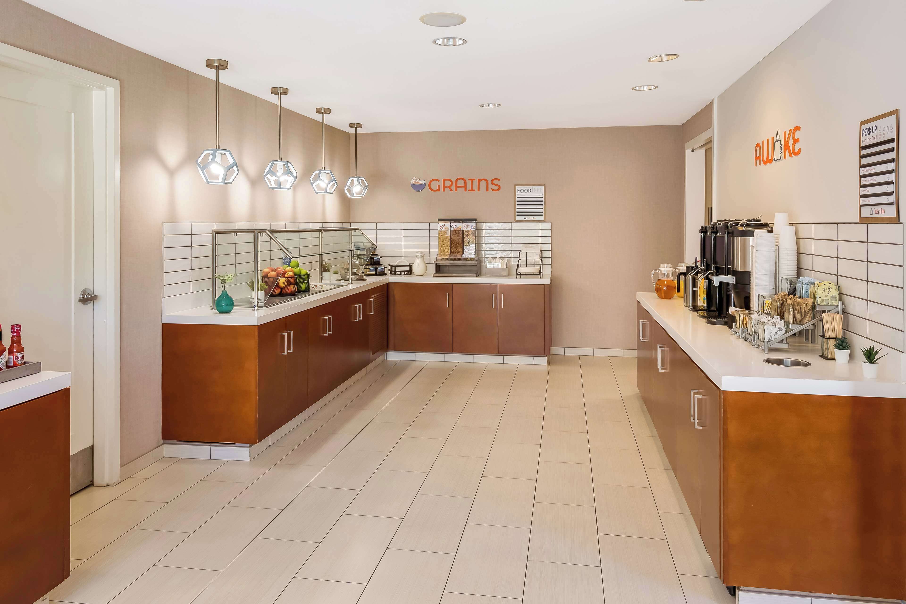 Una cocina moderna con una isla central, una cafetera y un cartel que dice 'AWAKE'.