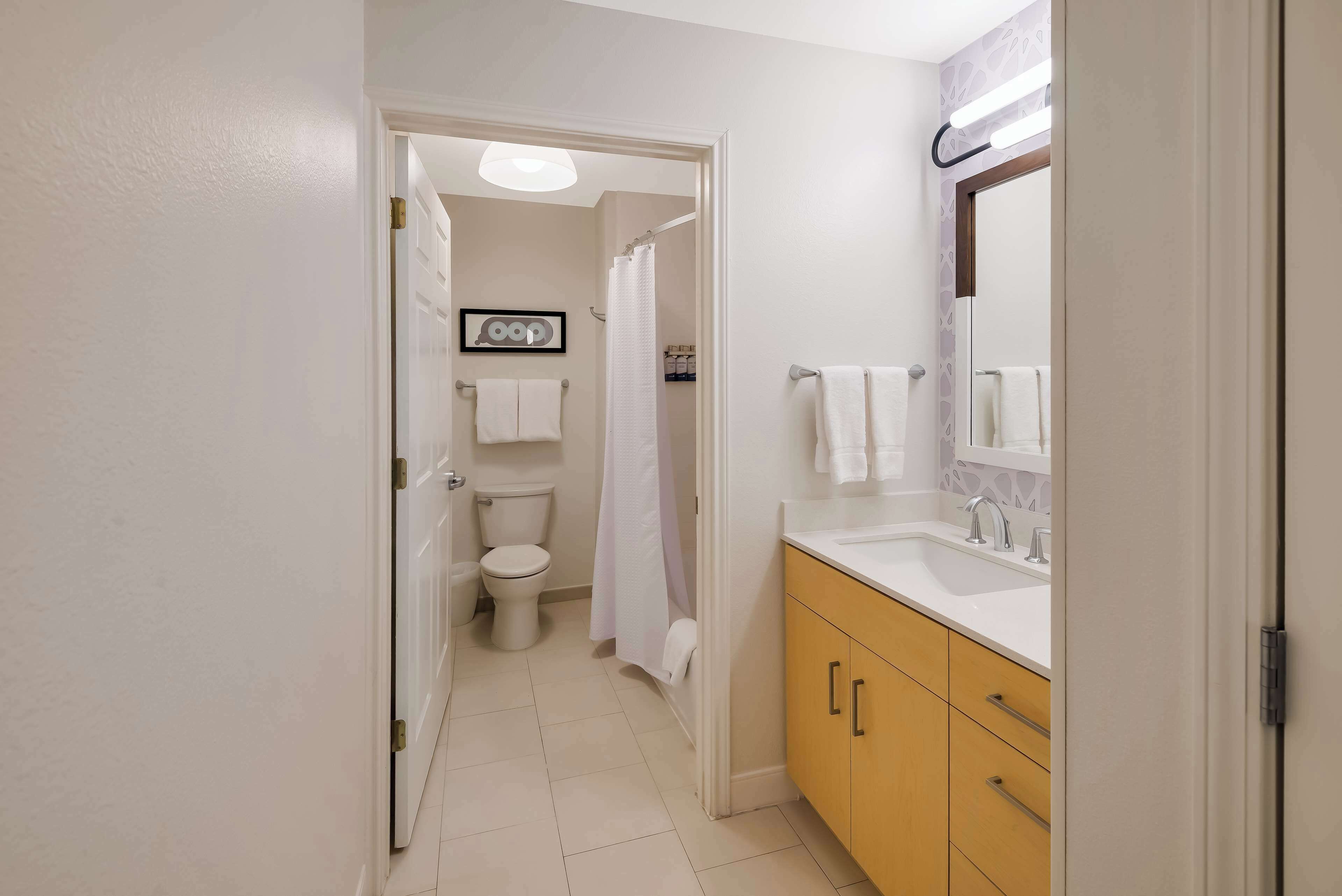 A bathroom with a toilet, sink, and shower area.