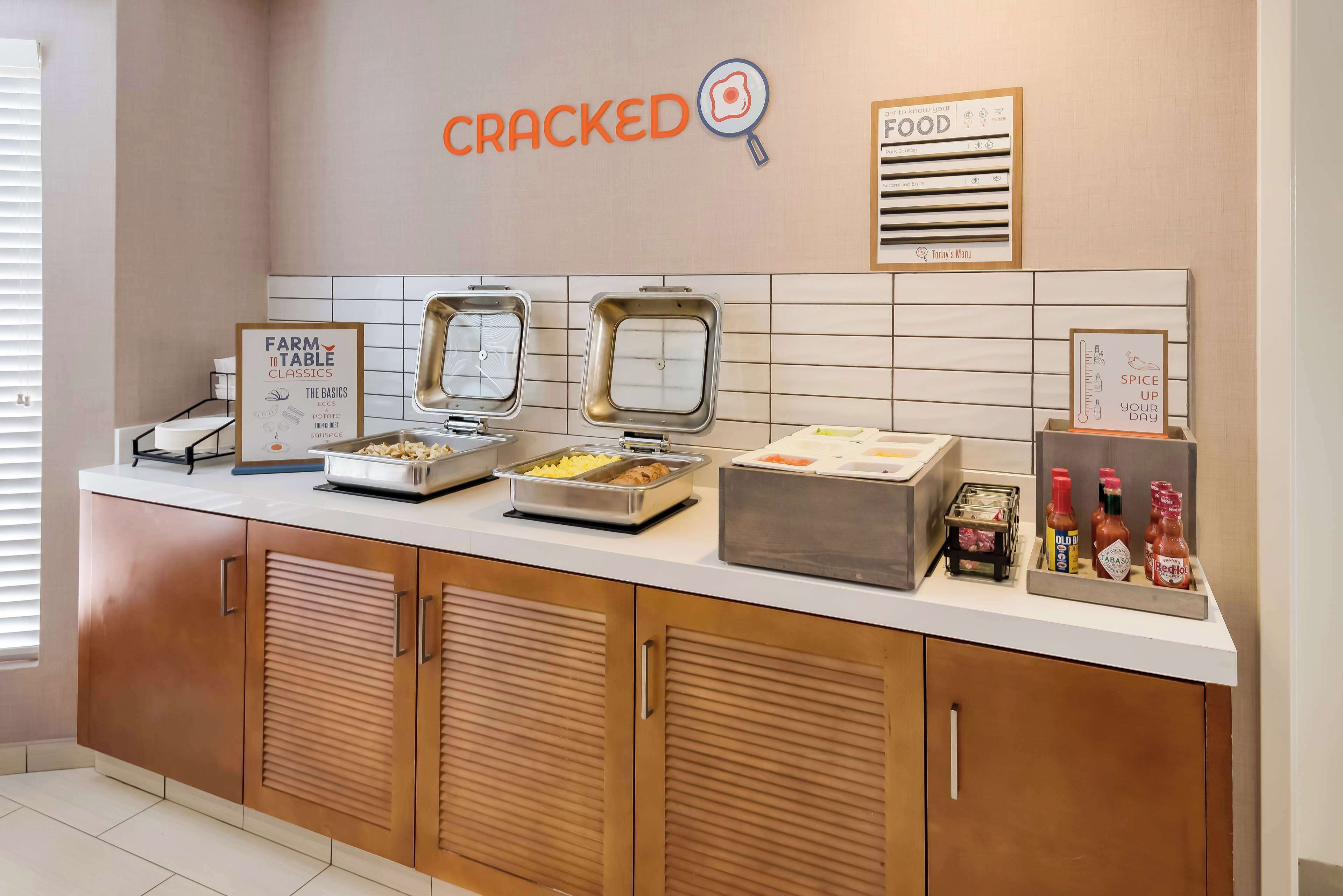 A breakfast bar with various food items and condiments.
