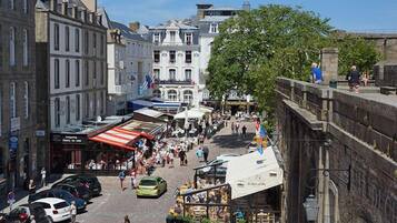 Une rue animée, bordée de bâtiments historiques, de cafés en plein air et de piétons.