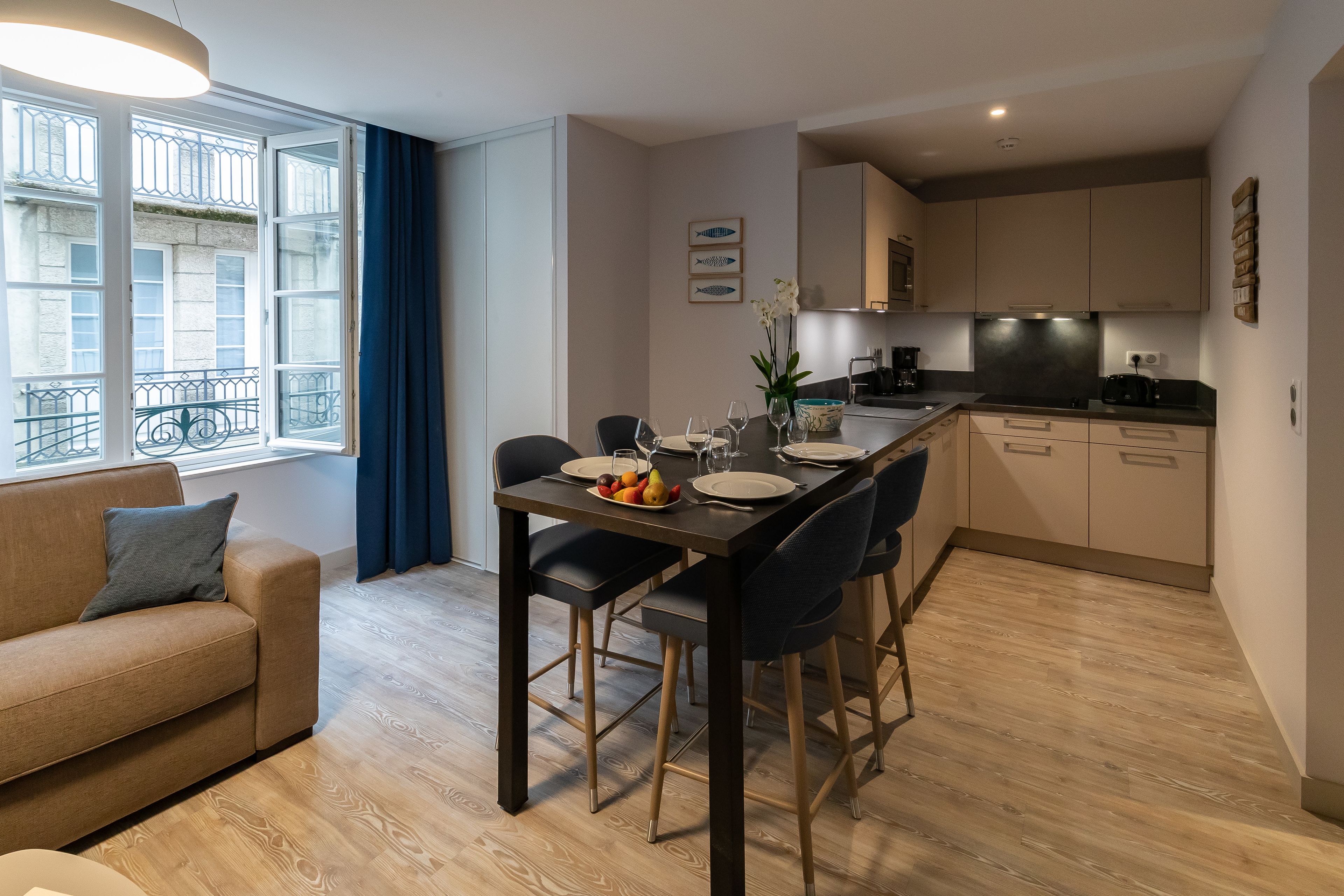 Un appartement moderne comprenant un coin repas, une cuisine et un canapé.