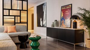 A modern living room with a sofa, a green coffee table, and a black cabinet. - Hotel Moderniste (Paris)