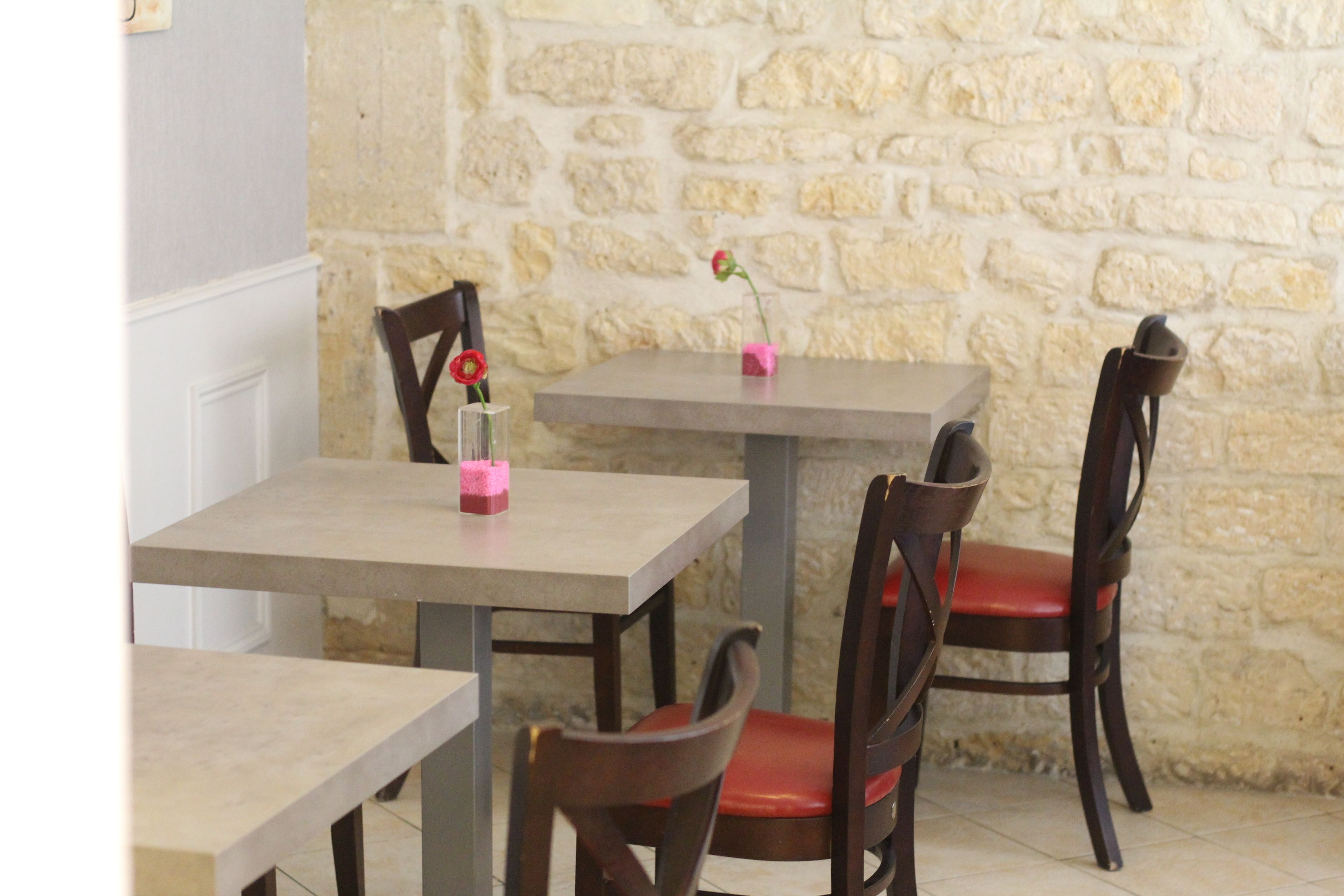 Un comedor con paredes de piedra, mesas y sillas de madera.