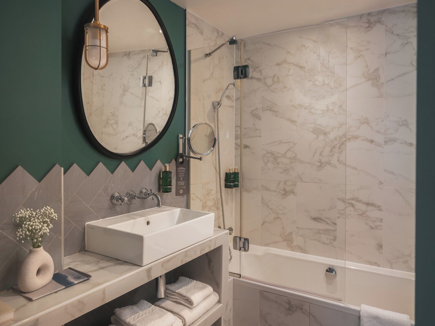 Une salle de bain moderne avec un lavabo blanc, un miroir et une douche.