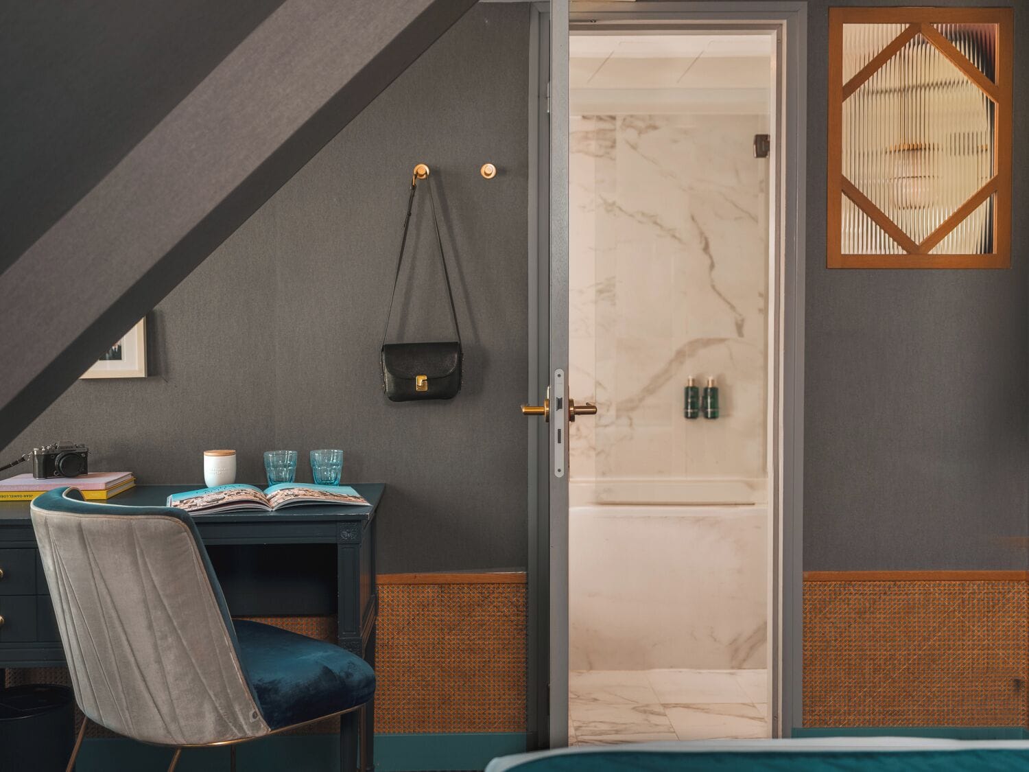 Un dormitorio moderno con escritorio, silla y vista al baño.