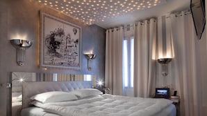 Un dormitorio moderno con una cama grande, detalles decorativos en la pared e iluminación ambiental.