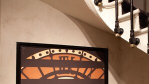 Una obra de arte enmarcada que muestra un reloj grande con un paisaje urbano de fondo.